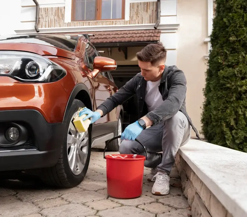 Lavage auto à domicile Bazoches-sur-Hoëne : professionnel intervenant sur un véhicule